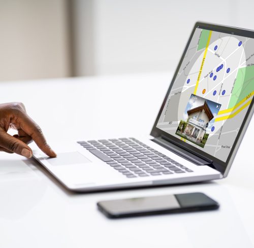 African American Woman Using Real Estate Map African American Woman Using Real Estate Map On Laptop Computer